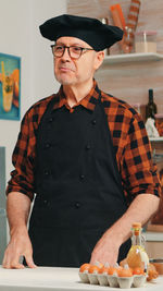 Portrait of young man standing at table