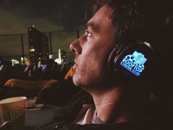 Portrait of young man using smart phone at night