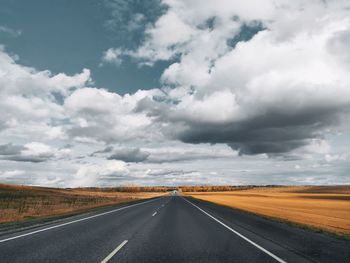 Empty road along countryside landscape