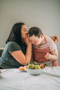 Lifestyle, education. elderly woman with down syndrome in the kitchen or classroom with teacher