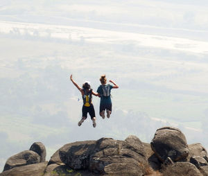 People playing on mountain against sky