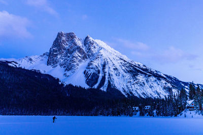 Cross country skier near large snow covered mountain in the rockies.