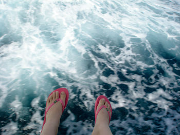 Low section of woman feet in swimming pool