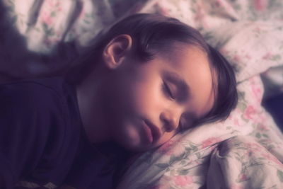 Close-up of baby sleeping on bed at home