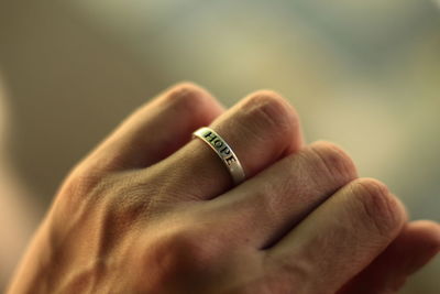 Cropped hand wearing ring with hope text outdoors