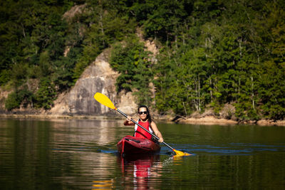 Young woman kayaking in lake