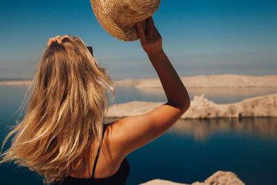 Rear view of woman in sea against sky