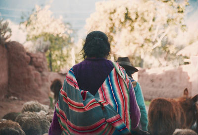 Rear view of woman walking on field