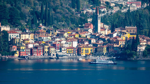 Sailboats in sea by buildings in city