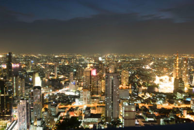 High angle view of illuminated buildings against sky at night