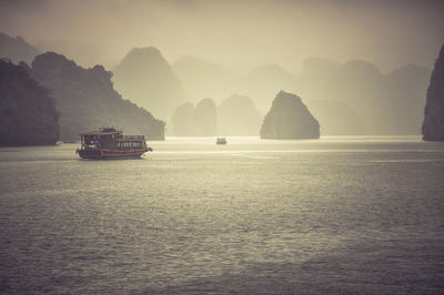 Boats in sea against sky during sunset