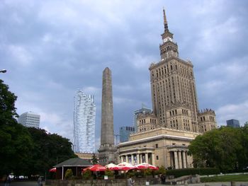 Low angle view of buildings against cloudy sky