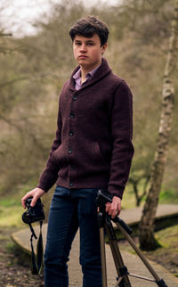 Portrait of man standing against trees