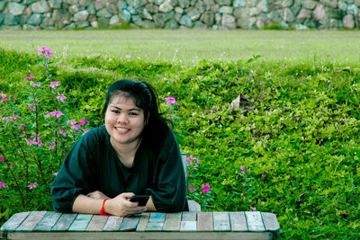 Portrait of a smiling young woman sitting outdoors