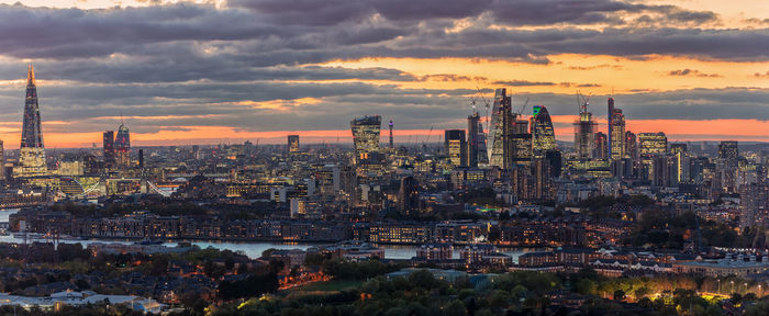 Aerial view of buildings against cloudy sky during sunset