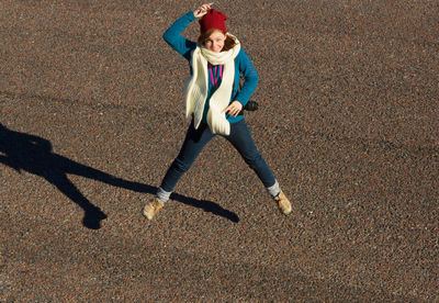 Full length portrait of happy teenage girl jumping on street