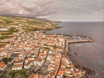 High angle view of buildings by sea against sky