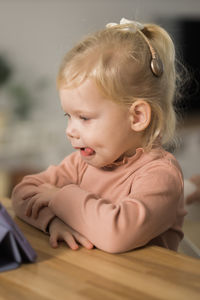 Close-up of cute baby boy sitting on table