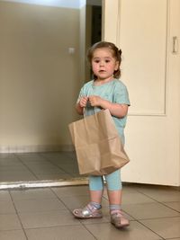 Portrait of cute girl standing on tiled floor