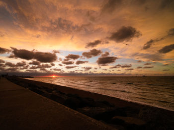 Scenic view of beach against sky during sunset