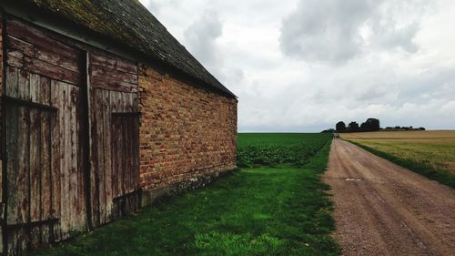 Road amidst field against sky