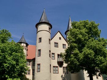 Trees and buildings against blue sky