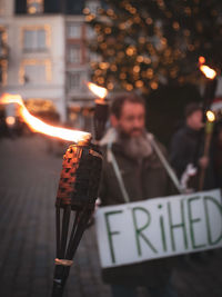 Midsection of man holding illuminated fire at night