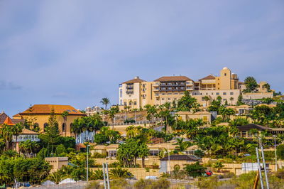 Buildings in town against blue sky