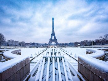 Snow covered buildings in city against sky