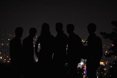 Silhouette people standing at night