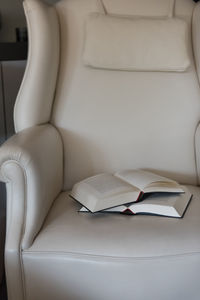 Close-up of open book on sofa at home