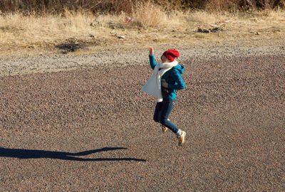 Happy girl jumping over street