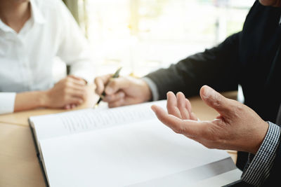 Close-up of woman holding hands on table