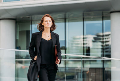 Portrait of young woman standing in city