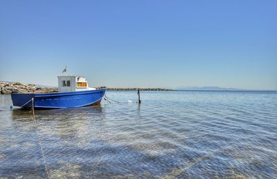 Ship moored on sea against clear sky