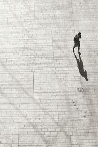 High angle view of man shadow on brick wall