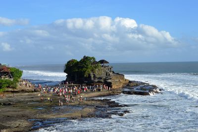 High angle view of crowd and tanah lot temple by sea