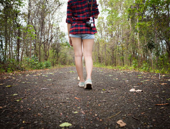 Low section of woman standing in forest