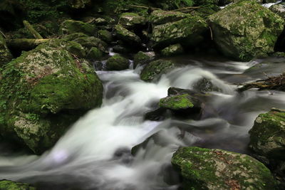 View of stream flowing through rocks