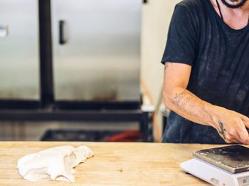 Man working on table making sourdough bread