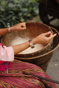 Midsection of woman holding basket thread