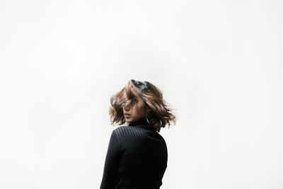 Rear view of woman standing against white background