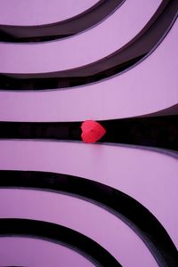 Close-up of brutalist building with heart shaped umbrella centered in the middle following leading l