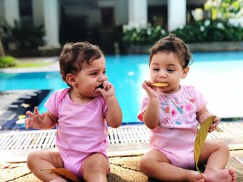 Sisters sitting at poolside