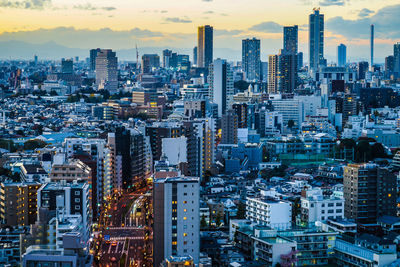 Aerial view of illuminated buildings in city against sky