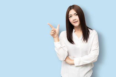 Portrait of a smiling young woman against white background