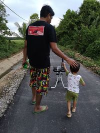 Rear view of two women walking on road