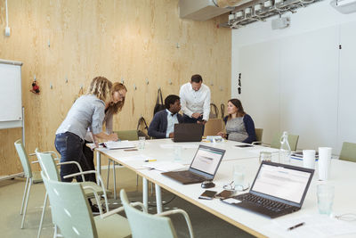 Male and female business coworkers discussing at conference table in meeting