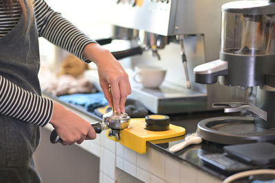 Midsection of woman working in kitchen at home