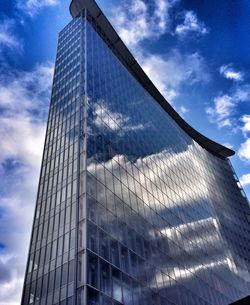 Low angle view of modern building against cloudy sky